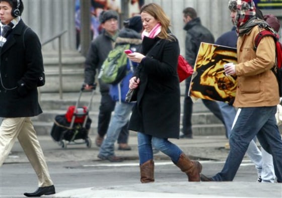 A pedestrian walks while using a phone in New York earlier this month. While smart phones and other electronic devices changed popular culture by offering an ability to always stay connected, it so swiftly turned into such a compelling need that a simple walk down the street is considered wasted time. 